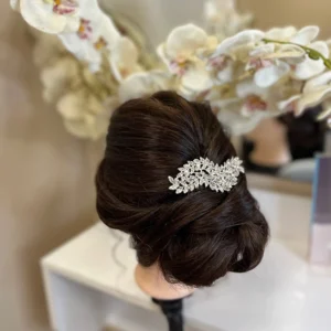 Сребристо украшение върху глава с прическа